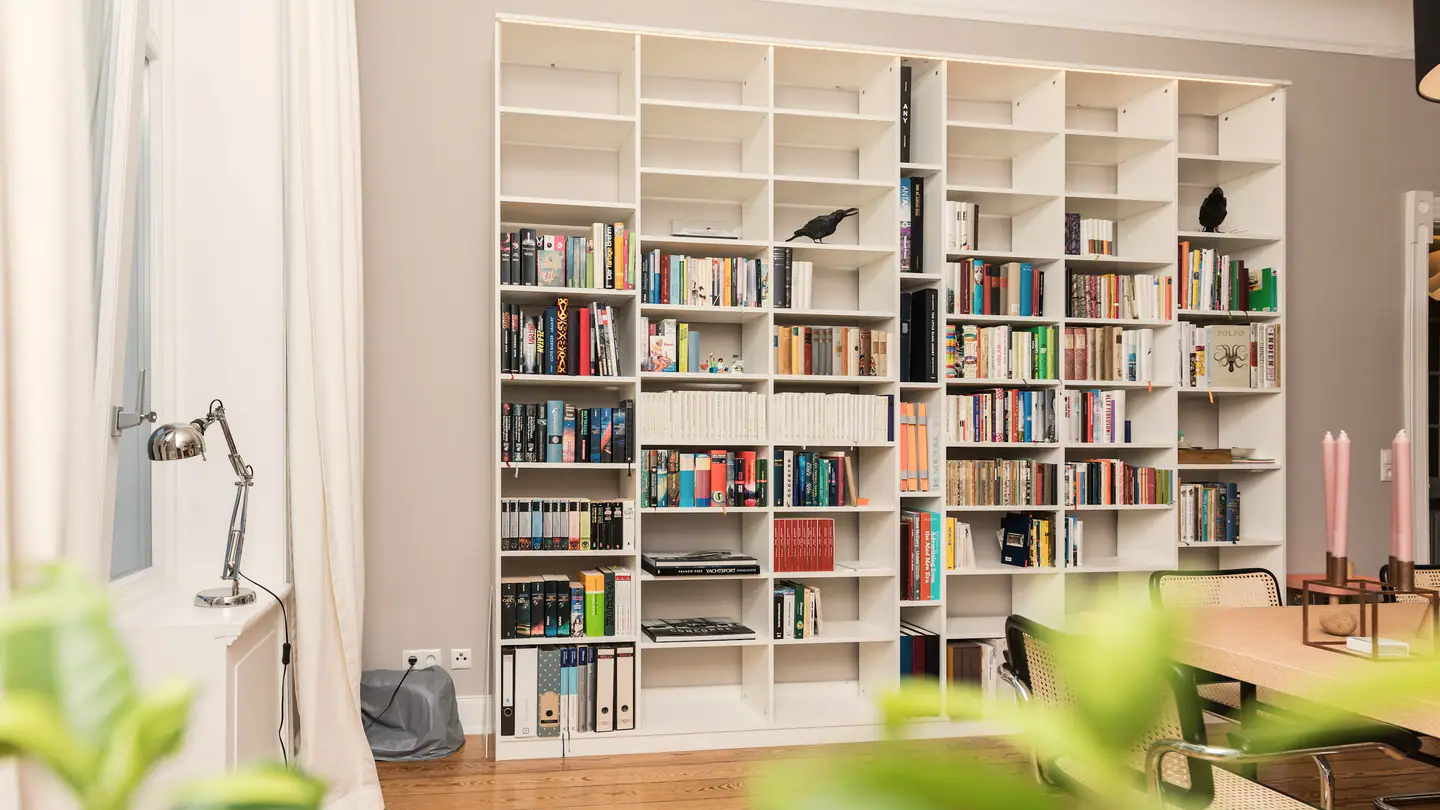 Bücherwand im Wohnzimmer, davor der Esstisch